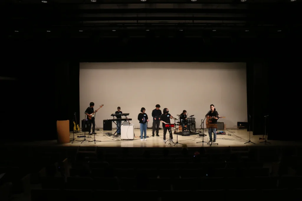 ぼくらのごちゃまぜフェス2025で、ホールのステージで演奏する若者たちのバンド