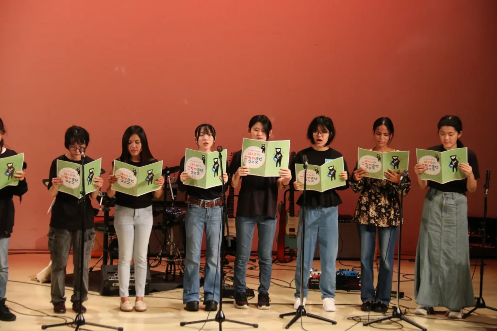ぼくらのごちゃまぜフェス2025で、冊子を手に歌う出演者たち